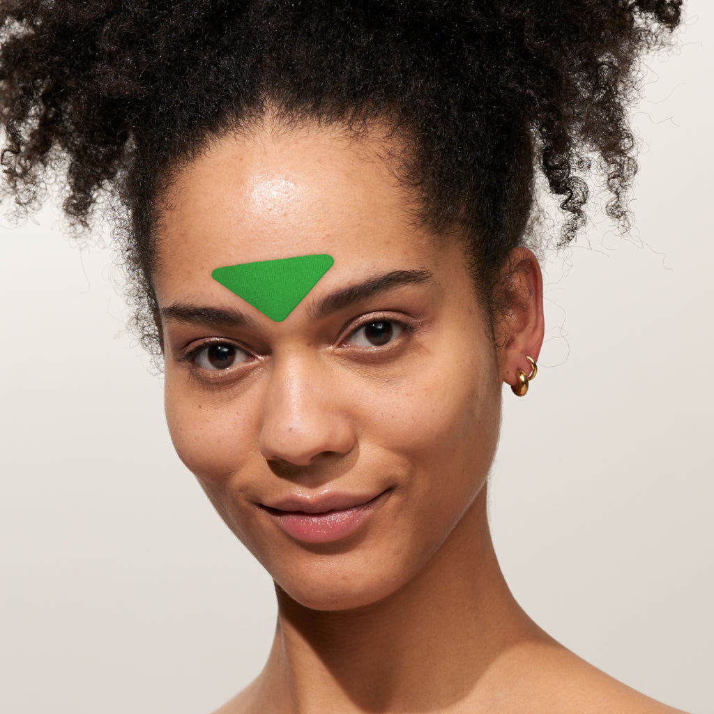 Model trägt APRICOT Zornesfalten Patches mit Aloe vera aus Bio-Baumwolle für die Stirnpartie